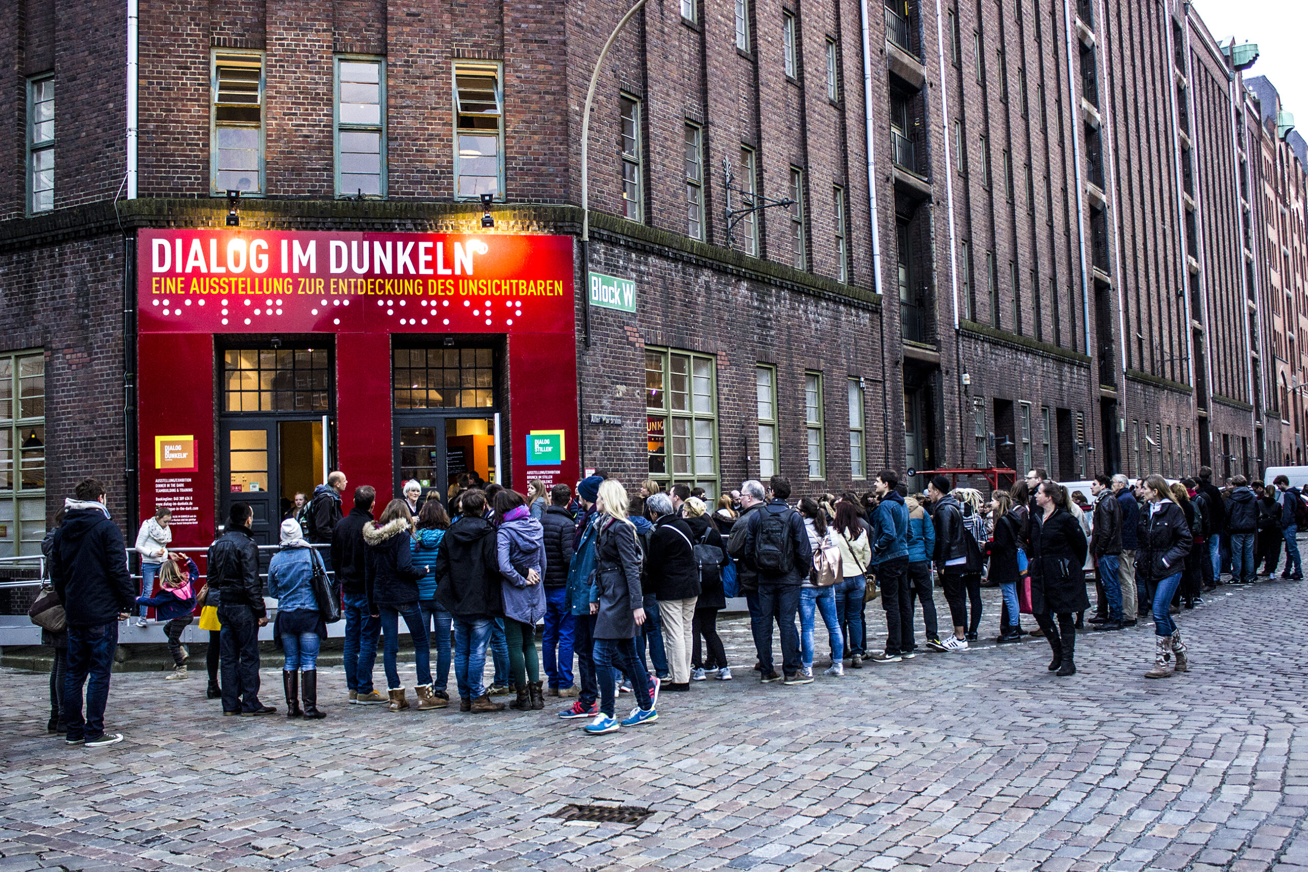 Außenansicht des Dialoghaus Hamburg mit wartenden Besuchergruppen.