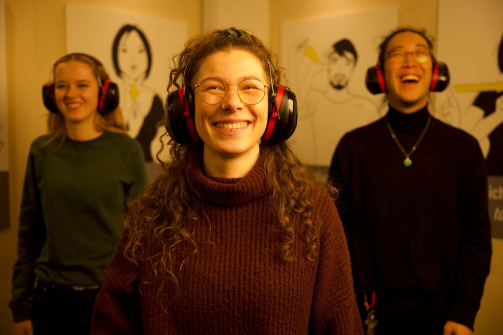 Eine Gruppe an Gästen der Ausstellung Dialog im Stillen lacht in die Kamera.