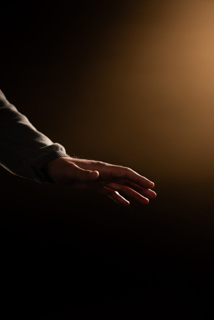 Eine Hand tastet in der Dunkelheit.